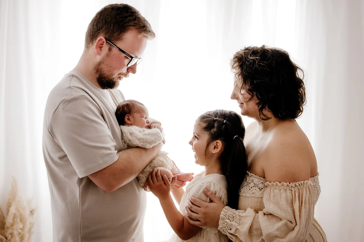 A family admiring their new baby